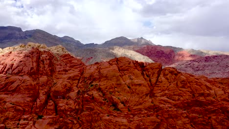 Aerial-Drone-shot-rising-up-above-the-Red-Rock-Canyon-Mountains-during-the-daytime-in-Las-Vegas-Nevada