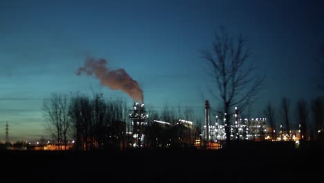 Industrial-zone-with-a-large-pipe-thick-white-smoke-is-poured-from-the-factory-pipe-at-night
