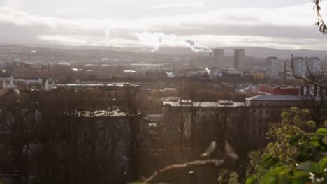 Above-view-city-time-lapse-with-steam-flowing-in-wind-clouds-streaming-by-and-city-life-below