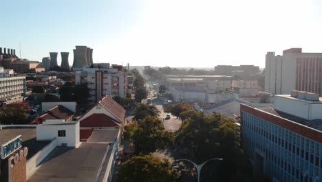 A-push-up-drone-shot-of-a-busy-city-area-Bulawayo,-Zimbabwe-at-sunset
