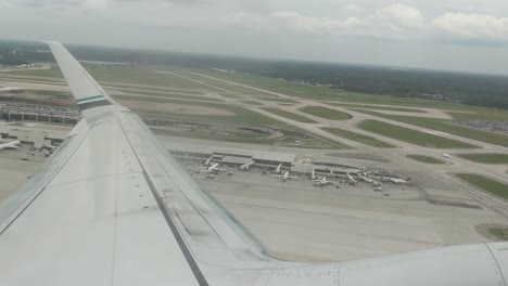 Looking-out-over-the-wing-as-the-plane-takes-off-from-Detroit-Metro,-DTW,-cloudy