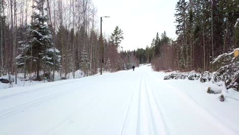 Cross-country-skier-skiing-in-high-speed,-cinematic-smooth-aerial-drone-shot