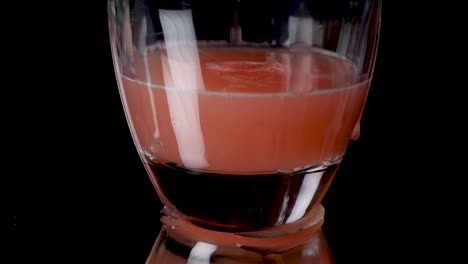 Pouring-in-Grapefruit-juice-in-a-glas,-some-of-it-spills-over