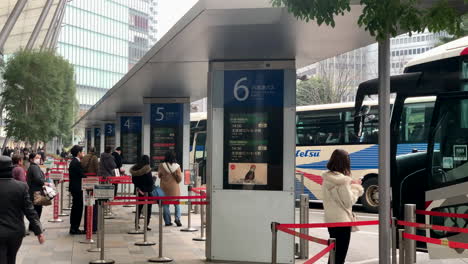Gente-Esperando-Y-Formando-Fila-En-La-Terminal-De-La-Parada-De-Autobús-Frente-A-La-Entrada-salida-Central-De-Yaesu-De-La-Estación-De-Tokio