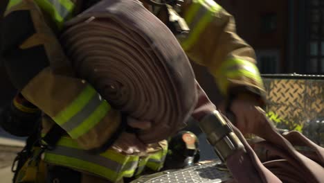Firefighter-pulls-a-fire-hose-out-of-a-firetruck-to-get-ready-to-fight-a-fire