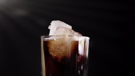 A-showcase-of-the-rotation-cola-with-ice-close-up-for-a-very-large-glass-of-cold-with-slow-motion-rotating