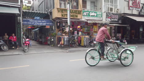 Old-Man-on-a-bicycle-taxi-riding-along-Bui-Vien-Steet,-red-light-district,-Ho-Chi-Minh-City,-Saigon,-Vietnam