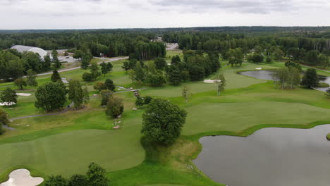 Green-golf-course-in-Sweden,-aerial-arc-shot