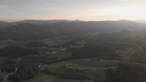Eine-Professionell-Aussehende-Luftaufnahme-Der-österreichischen-Alpen-Bei-Sonnenuntergang,-Die-Die-Weite,-Grüne,-Felsige-Landschaft-Und-Weinberge-Samt-Häusern-Und-Ausblick-Zeigt