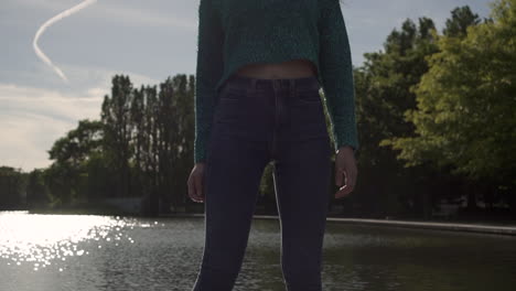 Gorgeous-Italian-fashion-model-posing-in-her-outfit-in-front-of-a-lake-in-London-at-golden-hour