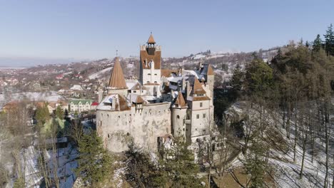 Orbit-around-Bran-Castle-in-Brasov,-Romania-on-a-sunny-winter-afternoon