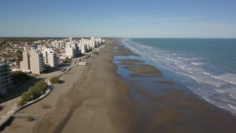 Aerial-Drone-view-going-up-of-empty-beach-with-low-tide,-in-Monte-Hermoso,-Argentina