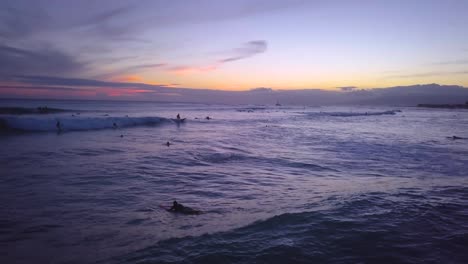Surfers-enjoy-the-sunset-at-Waikiki-as-they-catch-their-final-waves-at-dusk-on-the-Hawaiian-island-of-Oahu