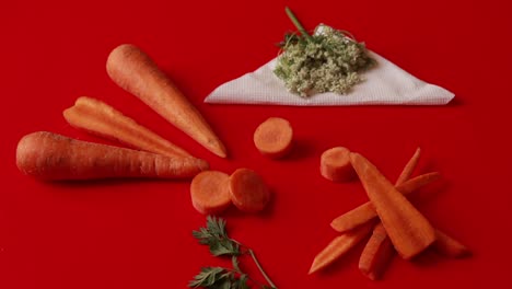 Carrot-vegetable-with-leaves-isolated-on-red-background-cutout