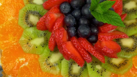 Rotating-shot-of-a-fruit-tart-with-the-circular-laying-of-colourful-fruits