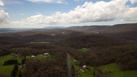 Aerial-drone-timelapse-of-central-Pennsylvania-mountains-in-the-spring-with-green-fields,-blue-skies,-and-large,-white-clouds