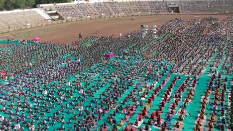 Luftaufnahmen-Von-Menschen,-Die-In-Einem-Stadion-In-Ahmednagar,-Indien,-Anlässlich-Des-Internationalen-Yoga-Tages-Zusammen-Mit-Schülern-Yoga-Machen