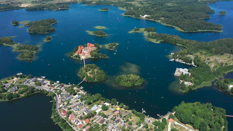 AERIAL:-Flying-in-Very-High-Altitude-Above-Trakai-Town-With-Trakai-Island-Castle-Visible-in-the-Background-Surounded-by-Lake-and-Forest-on-the-Bright-and-Sunny-Day