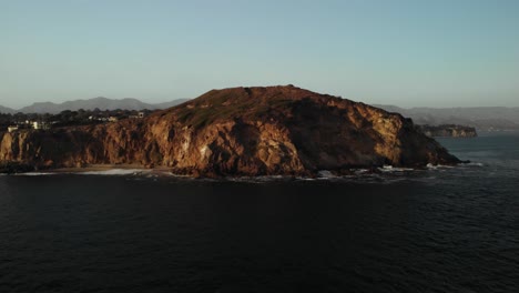 An-Aerial-Shot-of-the-Beautiful-Point-Dume-Cliff-in-Malibu-on-a-Calm-Evening-as-the-Vibrant-Sunsets