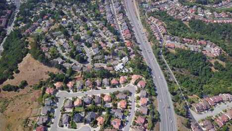 Timelapse-Aerial-hold-shot-of-houses-and-highway-in-suburbs-of-san-mateo-county,-sf-bay-area-california,-USA