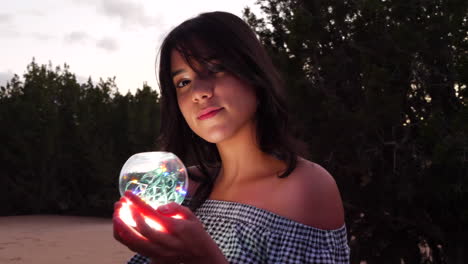 A-beautiful-mysterious-woman-with-a-magic-glowing-crystal-ball-in-an-enchanting-fantasy-land