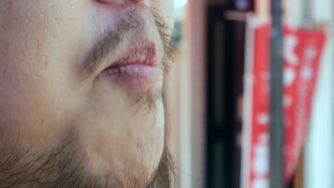 Zooming-to-the-mouth-of-man-with-beard-while-bite-and-chewing-fresh-strawberry--4K-UHD-video-movie-footage-short