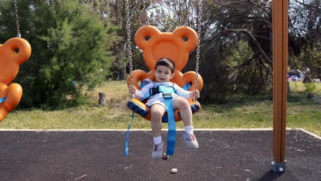 Zwei-Jahre-Alter-Junge,-Der-Sich-Auf-Einer-Teddybärförmigen-Schaukel-Im-Park-Entspannt