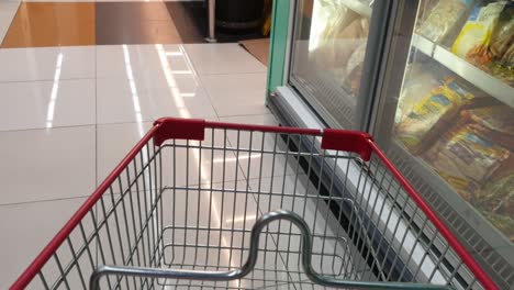 POV-shot-of-an-anonymous-shopper-with-a-cart-checking-the-different-sections-of-the-supermarket