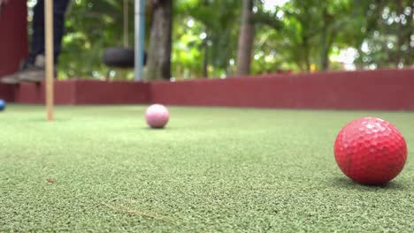 Close-and-Low-Shot-of-a-Golf-Ball-Going-in-the-Hole-on-the-Green-at-the-Mini-Golf-Course
