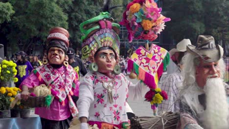 Indigenas-dressed-up-in-costume-waving-to-the-crowd-during-the-day-of-the-dead-celebration