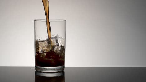 Slow-motion-beverage-pouring-into-glass-with-ice-cubes