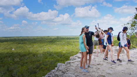 Wide-shot-of-people-enjoying-the-view-on-top-mayan-of-pyramid-at-Muyil-archeological-site,-Chunyaxche,-Quintana-Roo,-Mexico