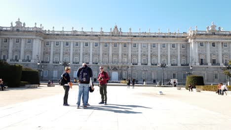 Caucasian-Tourists-with-cameras-standing-in-front-of-Palacio-Real,-The-Royal-Palace-in-Madrid,-exploring-Spain