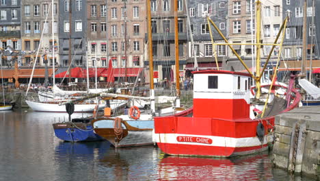 Sailboats-harbored-near-tall-colorful-buildings-in-Honfleur,-France