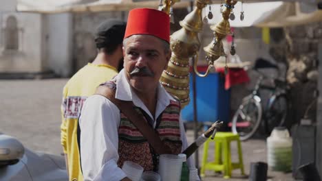 Portrait-shot-of-a-man-selling-the-traditional-licorice-drink-on-a-bazaar-in-downtown-Damascus