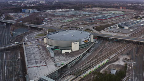 Aerial,-orbit,-drone-shot-around-the-Hartwall-arena,-on-a-cloudy-day,-in-Pasila,-Helsinki,-Finland