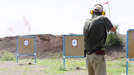 Ranger-Guide-target-practice-shoots-large-rifle-in-Madikwe,-S-Africa
