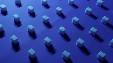 Left-to-right-panning-view-of-a-unique-cubic-background-with-white-sugar-cubes-symmetrically-arranged-in-rows-on-a-dark-blue-background,-3D-effect