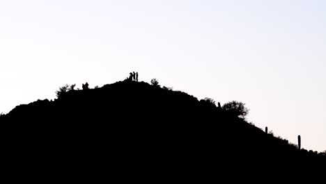 Silhouettes-of-five-people-on-the-top-of-a-mountain,-extreme-wide-shot