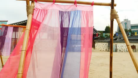 colorful-hanbok-fabric-hanging-on-traditional-korean-hanoaks-in-namsangol-hanoak-village
