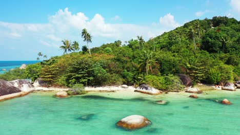 Paradise-calm-bay-with-turquoise-lagoon-washing-limestone-cliffs-on-shore-of-tropical-island-with-palm-trees-forest-in-Koh-Phangan,-Thailand
