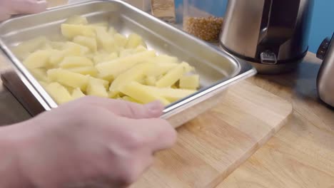 Slow-Motion-Slider-Shot-of-Shaking-Parboiled-Potatoes-for-Fries-in-a-Metal-Baking-Tray