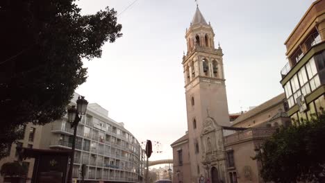 Coches-Y-Gente-Pasan-Por-La-Torre-De-La-Iglesia-Mudéjar-Gótica-En-Sevilla,-España