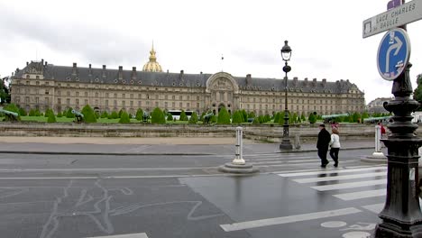 People-crossing-the-road-in-front-of-the-Army-Museum-building,-in-Paris,-France