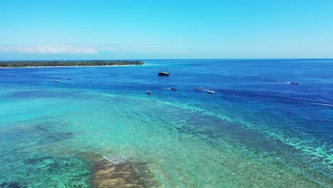 Vivid-colors-of-seascape-with-shallow-calm-water-of-turquoise-lagoon-surrounded-by-coral-reef-bordered-by-deep-blue-sea-in-Bali