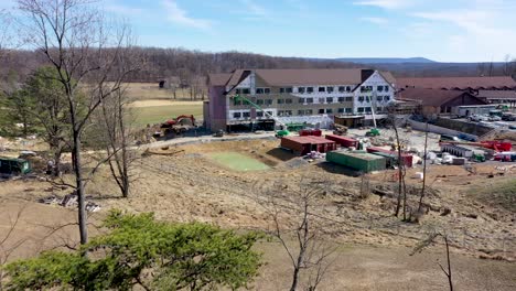 Aerial-push-in-over-the-trees-revealing-Cacapon-State-Park-lodge-expansion-construction-in-the-mountains-of-West-Virginia