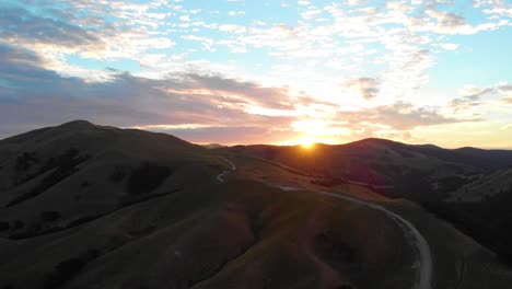 Colorful-sunrise-over-a-peaceful-winding-road-and-hills