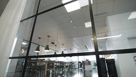 Gleitaufnahme-Eines-Schwarzen-Aluminiumfensterrahmens-Mit-Pausenraum-Im-Hintergrund