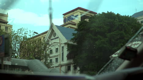 Hospital-Pusrawi-building-Revealed-As-Seen-From-Inside-the-driver-car's-mirror-,-Rainy-outside,-raindrops-on-outside-car-window