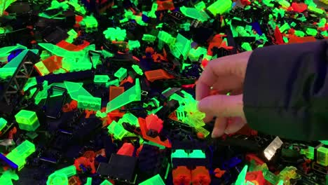 Schwarzer-Tisch,-Der-Mit-Leuchtenden-Neon-Lego-Stücken-Bedeckt-Ist